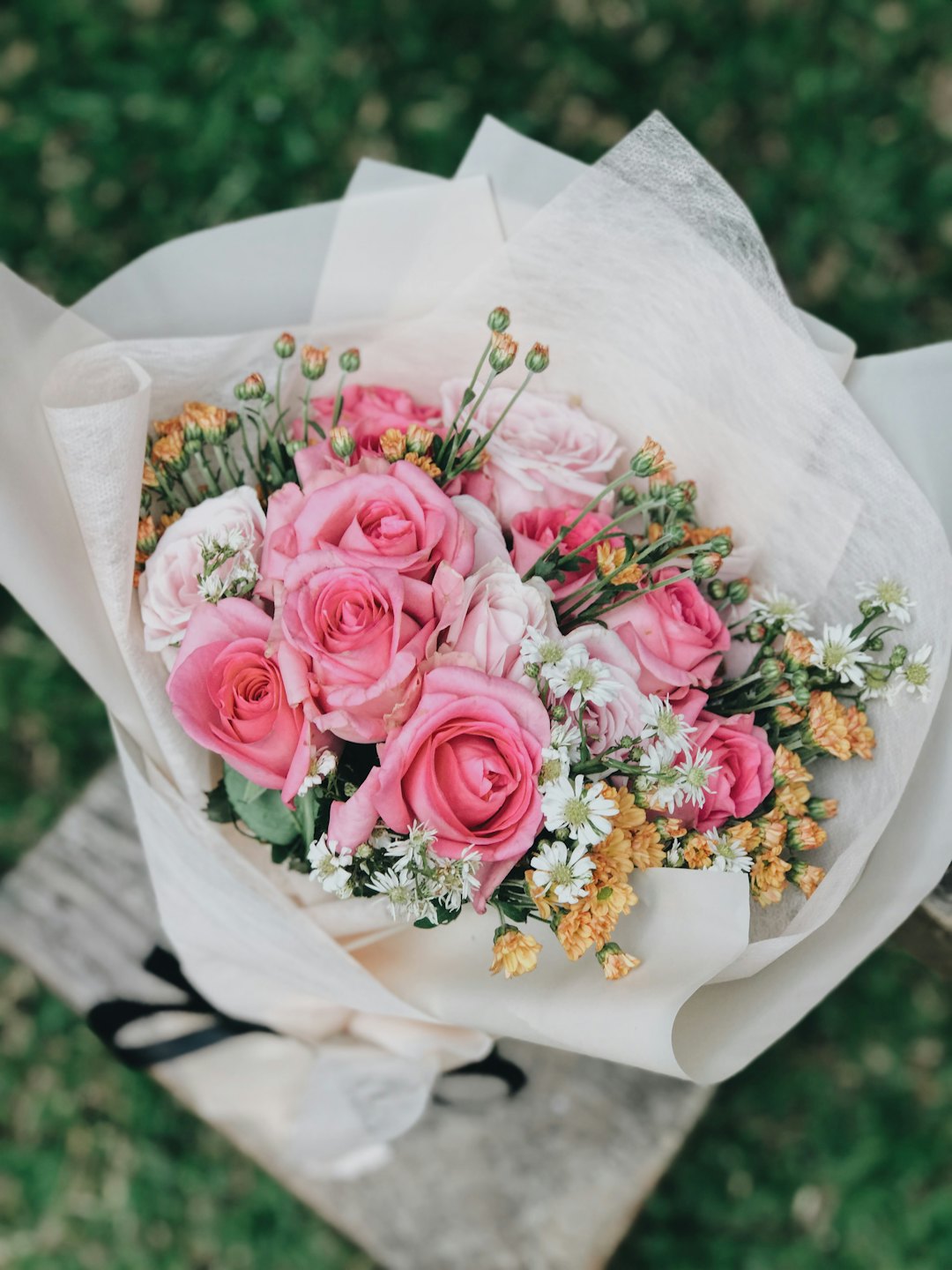 Rosa rosor, prästkragar och krysantemum i en blomsterbukett.